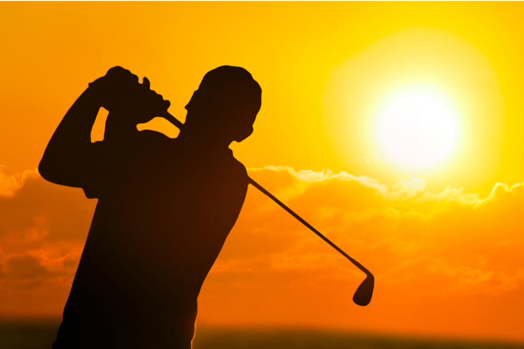 man golfing in sunset