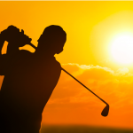 man golfing in sunset
