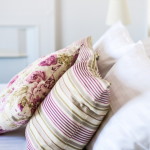 purple stripy pillows on white bed
